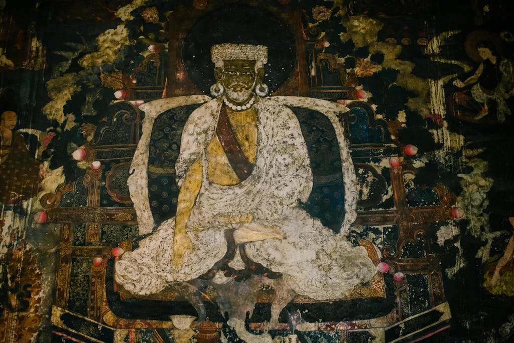 Ancient Tibetan Buddhist mural depicting a monk with intricate details and spiritual symbolism.